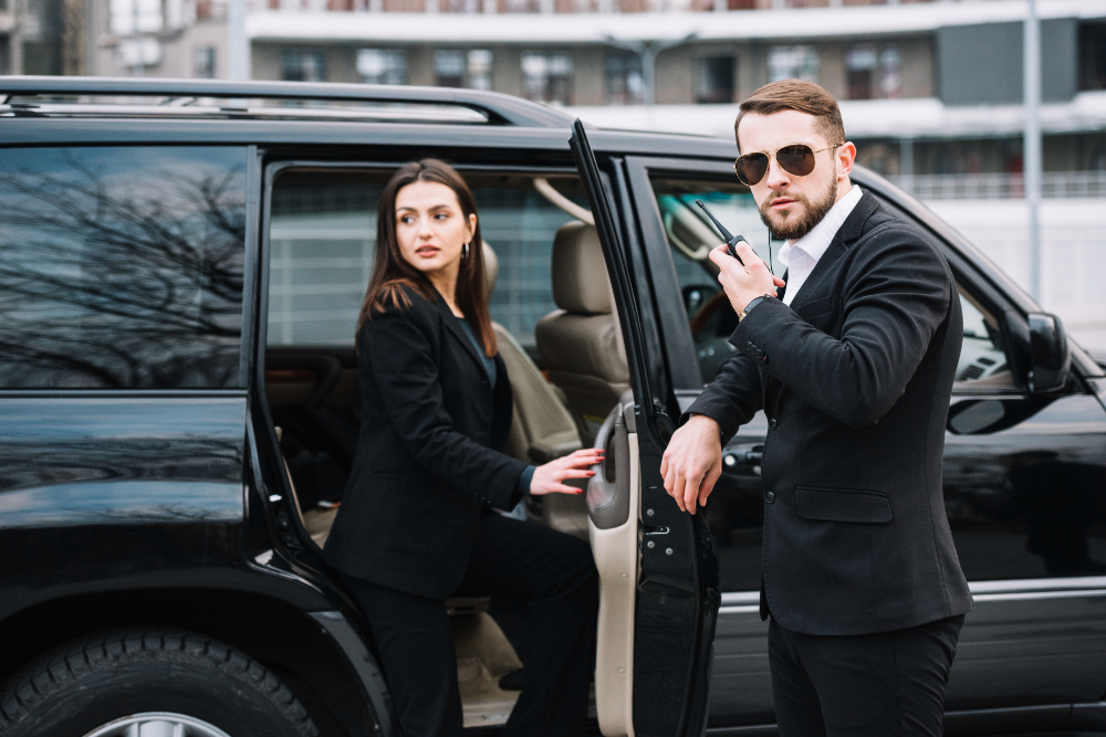 A professional couple in suits stands next to a black SUV, symbolizing tailored event security solutions.