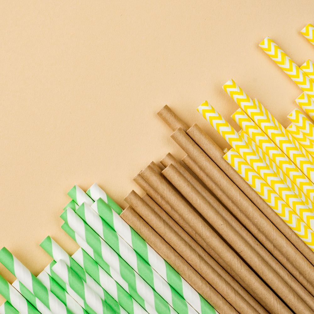 Wrapped paper straws in an array of colors on a sunny yellow background, designed for smoothies and bubble tea enjoyment.