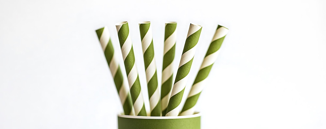 Green and white striped biodegradable paper straws promoting a sustainable and eco-friendly future.